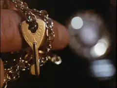 Close-up of the villain’s hand holding the key as he waits for Mrs. Peel to answer the phone