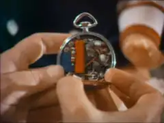 Emma inspects the inside of the pocket watch