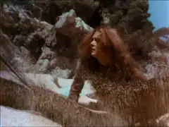 Mrs. Peel is trapped as the net under the sand lifts up