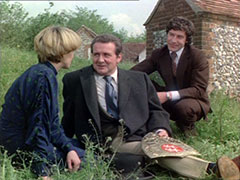 Purdey and Gambit flank Steed who sits on the ground, holding the shield which saved his life