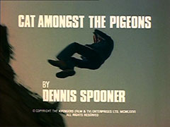 title card: white all caps text reading ‘CAT AMONGST THE PIGEONS BY DENNIS SPOONER’ superimposed on Merton falling backwards over a cliff