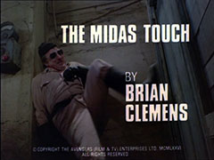 title card: white all caps text reading ‘THE MIDAS TOUCH BY BRIAN CLEMENS’ superimposed on a man in beige fatigues and a black woollen hat kicking in a door in a disused factory