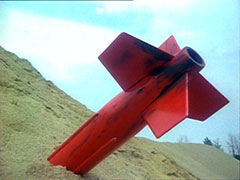 The unexploded missile lies buried in the sand dune