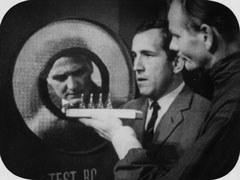 Steed, thinking himself infected and self-quarantined, peers out the porthole as Dr. Chalk shows him the real ampules have been returned and he is safe to come out