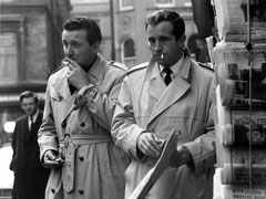 Publicity still: Steed and Dr. Keel pause in a Soho street, unsure where the fake MI5 agent they have been pursuing has gone (from a promotional shoot but similar to this episode’s chase sequence).