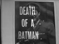 title card: white all caps text reading ‘DEATH OF A BATMAN’ superimposed on photograph of Steed in Army uniform