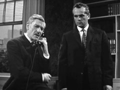 Van Doren looks on uneasily as Lord Teale speaks on the phone