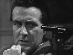 Steed is perturbed by Van Doren’s revolver, which has just appeared near his left temple