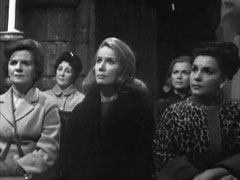 Marion Howard sits in the audience of the seance with Cathy keeping an eye on her from the back