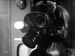 Close-up of Cathy wearing a gas mask as the heist begins
