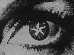 A photomontage of a close-up of an eye, the pupil replaced with the flower of a star jasmine