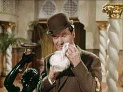Steed peers inside a teapot to see if the missing corpse is there