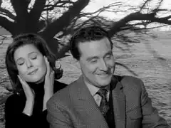 Steed happily toots the engine’s horn while Mrs. Peel, sitting behind him, covers her ears