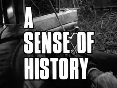 title card: white all caps text reading ‘A SENSE OF HISTORY’ outline din black and superimposed on Groom, slumped in the passenger seat with an arrow in his back