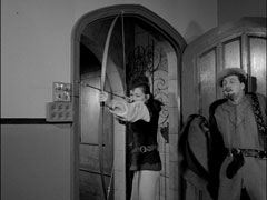 Mrs. Peel and Steed burst into the lecture room and she prepares to fire an arrow to disarm Grindley