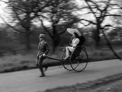 Steed conveys Emma away in a rickshaw (or at least, their stunt doubles do)