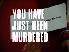 title card: white all caps text with thin black dropshadow to the right reading ‘YOU HAVE JUST BEEN MURDERED’ superimposed on the business card bearing the same text lying on the leather-topped desk
