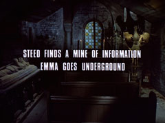 subtitle card: white all caps text with black dropshadow to the left reading ‘STEED FINDS A MINE OF INFORMATION
			EMMA GOES UNDERGROUND’ superimposed on the gloomy chapel interior