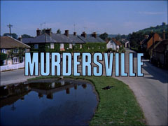 title card: white all caps text outlined in black reading ‘MURDERSVILLE’ superimposed on an aerial view of an English village, a man lying dead in the grass beside the pond