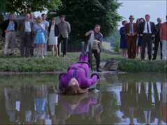 Mickel controls the dunking stool as Emma is submerged into the village pond, the villagers watch on