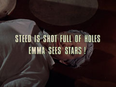 subtitle card: white all caps text with black dropshadow to the left reading ‘STEED IS SHOT FULL OF HOLES
			EMMA SEES STARS!’ superimposed on a close-up of Cosgrove lying dead on the floor with his hair turned grey