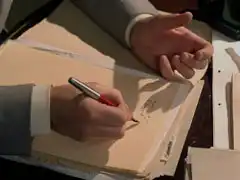 Mercer’s hand cramps into a claw as he writes his report