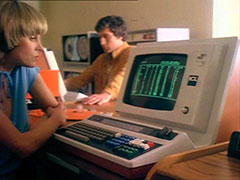 Purdey gazes with resignation at the green-screened ICL terminal she's having to programme to get some information, Gambit sits at another terminal across the table near the mainframe