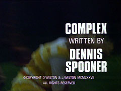 title card: white all caps text reading ‘COMPLEX 
					WRITTEN BY
					DENNIS
					SPOONER’ superimposed on an out of focus close-up shot of Purdey running across a field at night, about to bend down