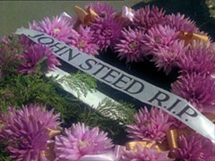 A purple floral wreath bearing the ribbon ‘JOHN STEED R.I.P.’
