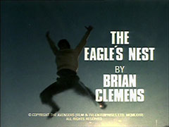 title card: white all caps text reading ‘THE EAGLE’S NEST BY BRIAN CLEMENS’ superimposed on a freeze frame of Stannard leaping off the cliff, arms and legs outstretched