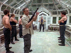 Inside the greenhouse, Nada prepares to deflect submachinegun bullets with his bare hands