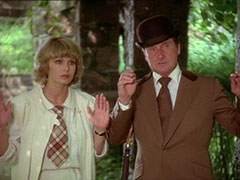 Purdey and Steed raise their hands in surrender