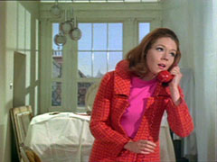 Flashback to 1967: Mrs Peel answers the telephone wearing a pink dress and red and pick checked coat - it looks like she’s just started redocrating her flat as the furninture is covered with cloth