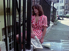 A young woman lies asleep outside her door, the newspaper and milk dropped, and her red and white striped dressinggown coming undone