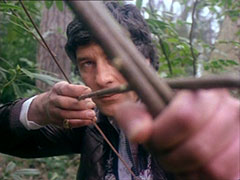Gambit aims his makeshift bow and arrow, the bow and the hand holding it blurring as they near the camera
