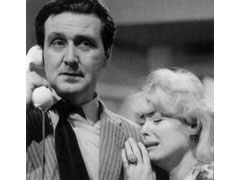 Publicity still: Steed makes a phone call while Fiona sobbs against his shoulder