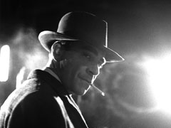 Publicity still: Frank Preston dramatically lit by a streetlight, looking like Bogart