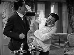 publicity still: Steed prevents U Meng, disguised as a waiter, from assassinating the King