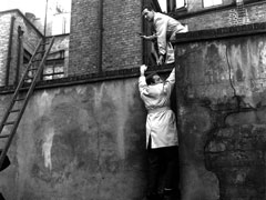 Publicity still: Dr Keel and Steed scale a wall in the back streets of the West End as they continue to pursue Commander Reece (image may be from a promotional shoot).