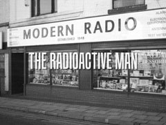 title card: THE RADIOACTIVE MAN superimposed on an exterior shot of an electronics repair shop (recreated by Richard McGinlay)