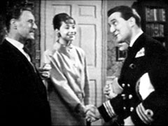 Steed, disguised as a Naval officer, meets Groves and Lisa at their school