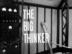 title card: white all caps text reading 'THE BIG THINKER' superimposed on a croner of the lab, showing a maniframe computer rack and cooling pipe