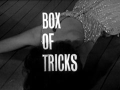 title card: white all caps text reading ‘BOX OF TRICKS’ superimposed on Valerie’s body, lying face down on the floor with a bullet wound in her back