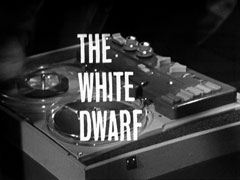 title card: white all caps text reading ‘THE WHITE DWARF’ superimposed on a reel to reel tape deck