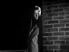 Steed takes cover from Max’s gunfire behind a brick wall