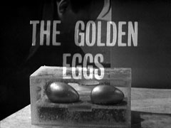 title card: white all caps text reading 'THE GOLDEN EGGS' superimposed on two gold eggs in a glass box