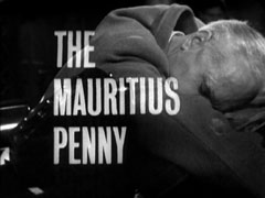 title card: white all caps text reading ‘THE MAURITIUS PENNY’ superimposed on Peckham’s body slumped over his desk