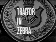 title card: white all caps text reading 'TRAITOR IN ZEBRA' superimposed on the coat of arms of the base - a zebra in a shield surmounted by a crown, surrounded by laurel leaves