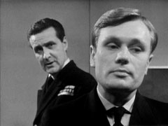 Steed, standing behind Sub-Lt Crane, questions him
