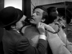 Steed roughs up Benson, pinning him against the mirror of his cabin with his umbrella